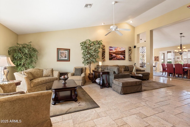 living room featuring visible vents, high vaulted ceiling, stone tile floors, and ceiling fan with notable chandelier