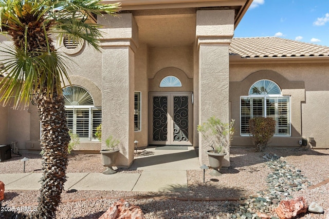 doorway to property featuring stucco siding and a tiled roof