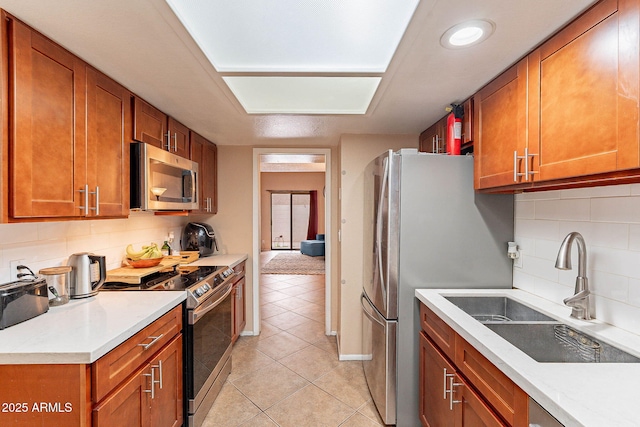 7764 N 19th Dr, Phoenix, AZ 85021 - kitchen with stainless steel appliances, tasteful backsplash, sink, and light tile patterned floors