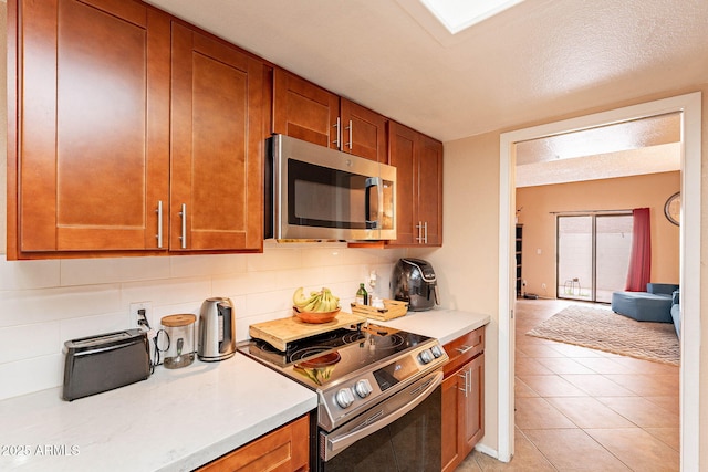 7764 N 19th Dr, Phoenix, AZ 85021 - kitchen with tasteful backsplash, stainless steel appliances, a textured ceiling, and light tile patterned floors