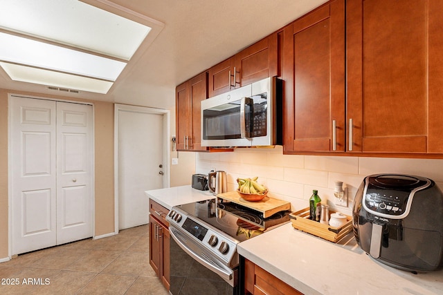 7764 N 19th Dr, Phoenix, AZ 85021 - kitchen featuring tasteful backsplash, stainless steel appliances, and light tile patterned floors
