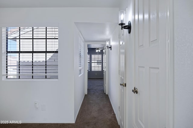 hall featuring carpet flooring and baseboards