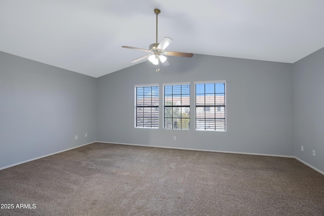 carpeted spare room featuring vaulted ceiling, a ceiling fan, and baseboards