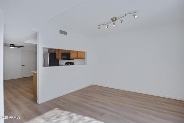 unfurnished living room featuring visible vents, baseboards, light wood-style flooring, ceiling fan, and track lighting