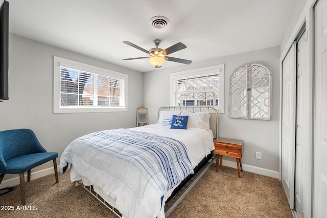 carpeted bedroom with a closet, visible vents, a ceiling fan, and baseboards