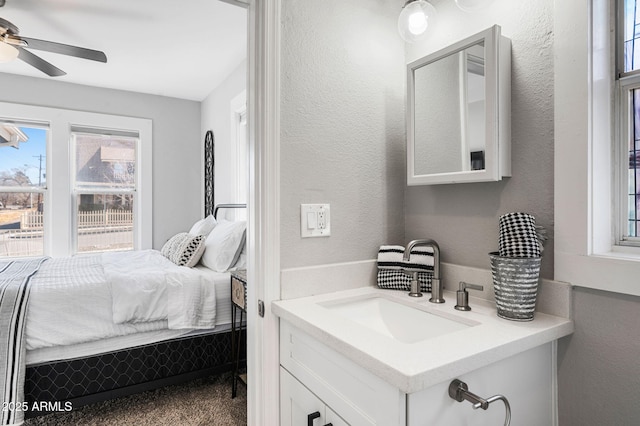 bedroom featuring a sink, a ceiling fan, and a textured wall