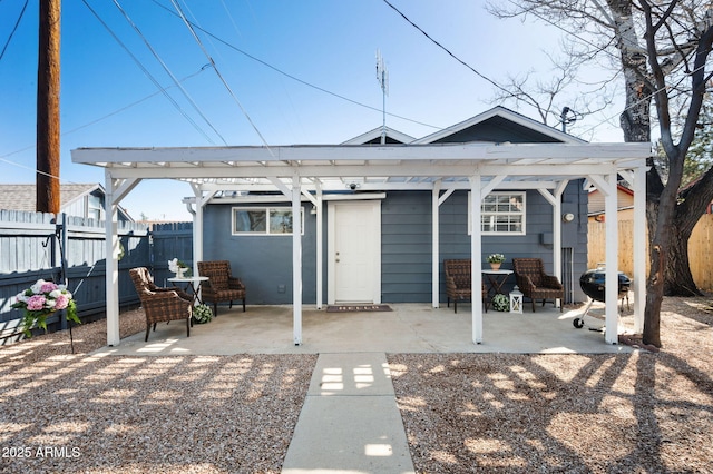 rear view of house with a patio area, a pergola, and fence