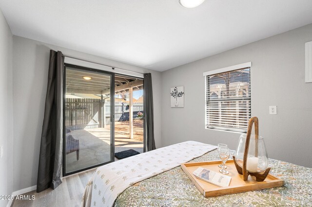 bedroom featuring wood finished floors and access to exterior