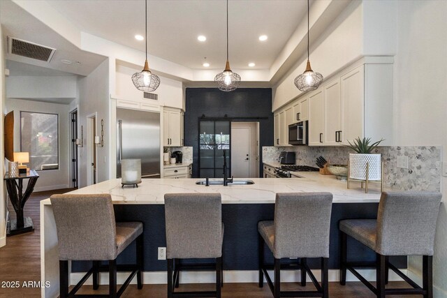 33667 N 71st Way, Scottsdale, AZ 85266 - kitchen featuring a sink, appliances with stainless steel finishes, a peninsula, backsplash, and light stone counters
