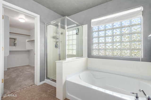 bathroom featuring tile patterned flooring, shower with separate bathtub, and a healthy amount of sunlight