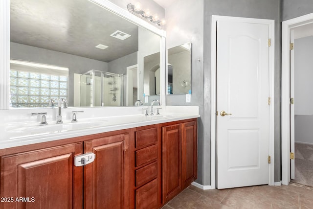 bathroom featuring tile patterned floors, a shower with door, and vanity