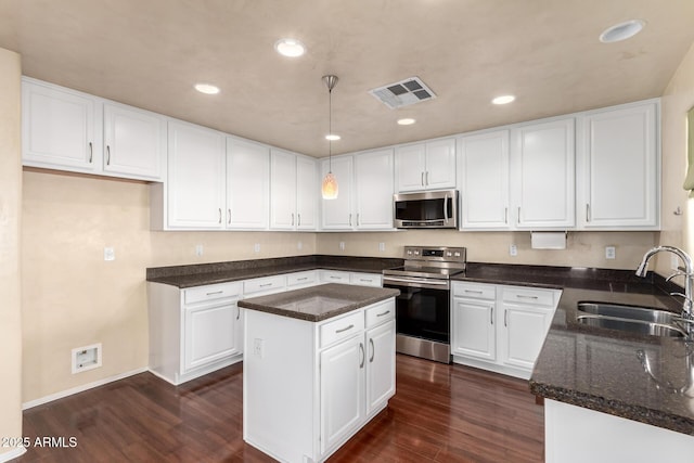 kitchen with sink, white cabinetry, stainless steel appliances, dark hardwood / wood-style floors, and a kitchen island