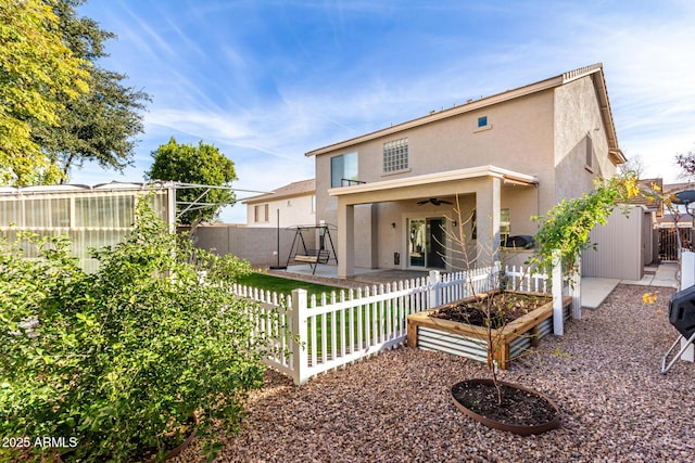 back of property with ceiling fan and a patio