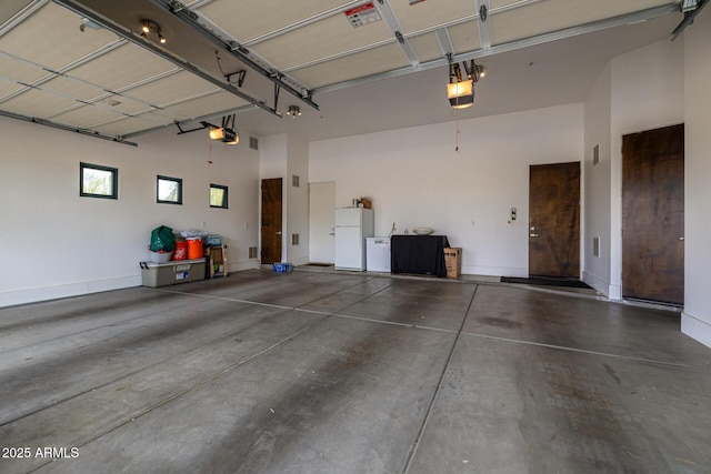 garage with a garage door opener and freestanding refrigerator