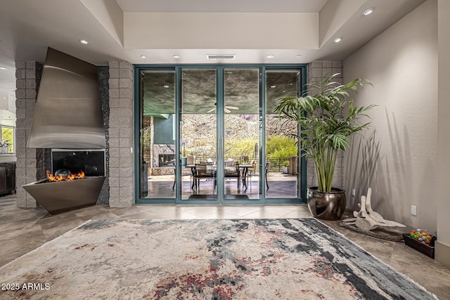 property entrance with a patio area, visible vents, and a large fireplace