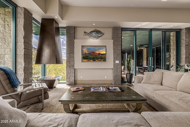 living area featuring expansive windows and ceiling fan