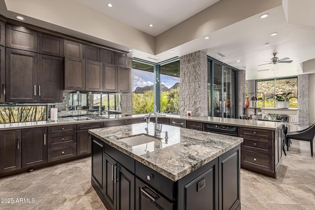 kitchen with an island with sink, a sink, and recessed lighting