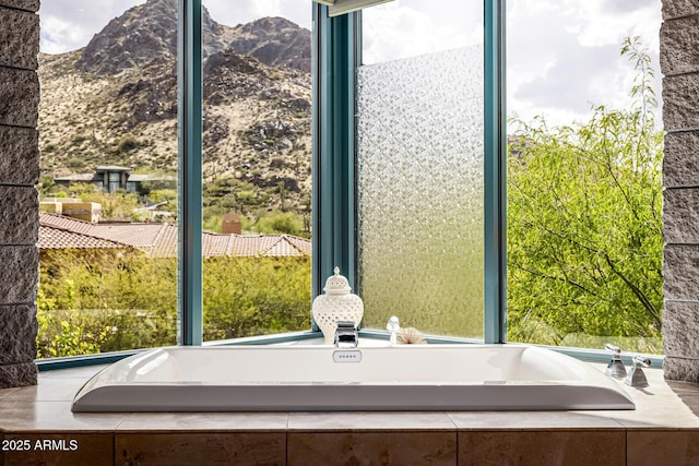 bathroom featuring a bath and a mountain view