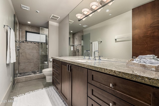 bathroom with tile patterned floors, toilet, visible vents, a shower stall, and vanity