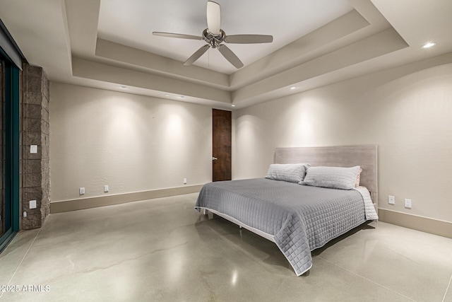 bedroom featuring baseboards, finished concrete floors, recessed lighting, a fireplace, and a raised ceiling