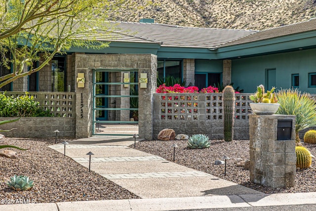 view of exterior entry featuring a tiled roof and stucco siding