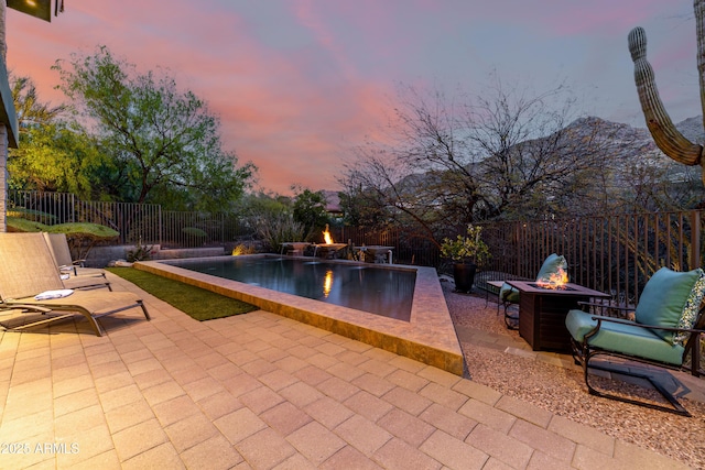 view of swimming pool featuring a fenced backyard, a fenced in pool, a fire pit, and a patio