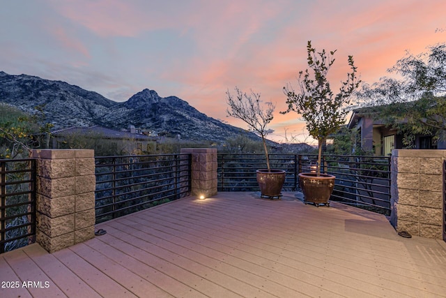 deck at dusk featuring a mountain view