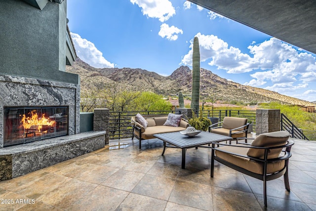 view of patio featuring an outdoor stone fireplace and a mountain view