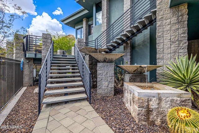 view of home's community with stairway and fence