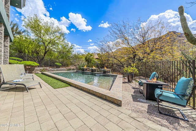view of swimming pool featuring a fire pit, a fenced in pool, a fenced backyard, and a patio
