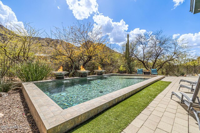 view of pool with a fenced in pool, a patio area, a fenced backyard, and a mountain view