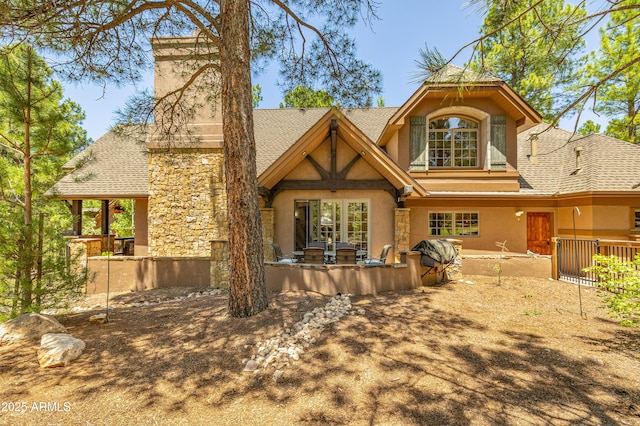 1697 E Solitude Ct Unit 22, Flagstaff, AZ 86005 - back of property featuring stucco siding, a shingled roof, and stone siding