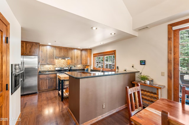 1697 E Solitude Ct Unit 22, Flagstaff, AZ 86005 - kitchen featuring stainless steel appliances, under cabinet range hood, dark countertops, dark wood-style floors, and recessed lighting