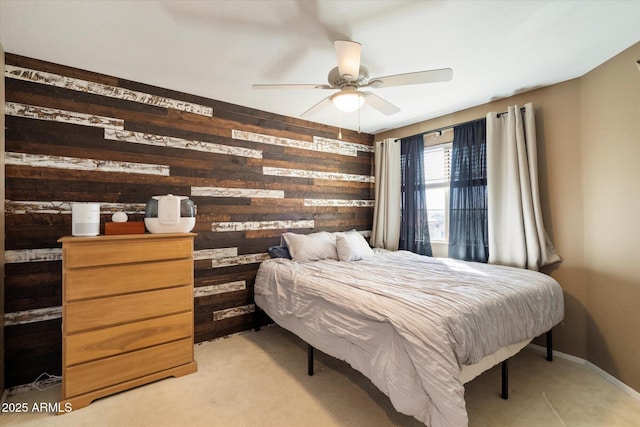 bedroom featuring wood walls, baseboards, and a ceiling fan