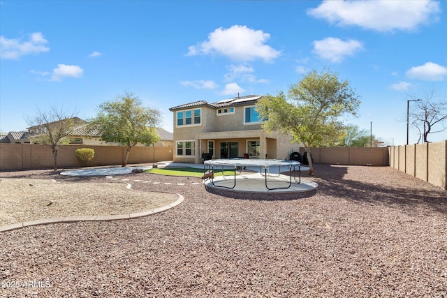 back of property with a patio area, a fenced backyard, roof mounted solar panels, and stucco siding