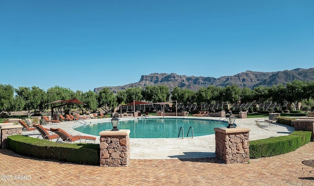 pool featuring a patio area, a mountain view, and playground community