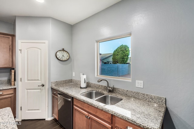 kitchen with sink, dark wood-type flooring, stainless steel dishwasher, and light stone countertops