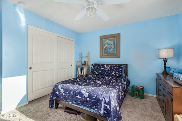 carpeted bedroom with ceiling fan and a closet