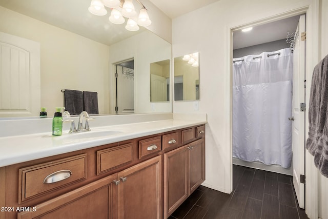 bathroom with vanity, curtained shower, and an inviting chandelier