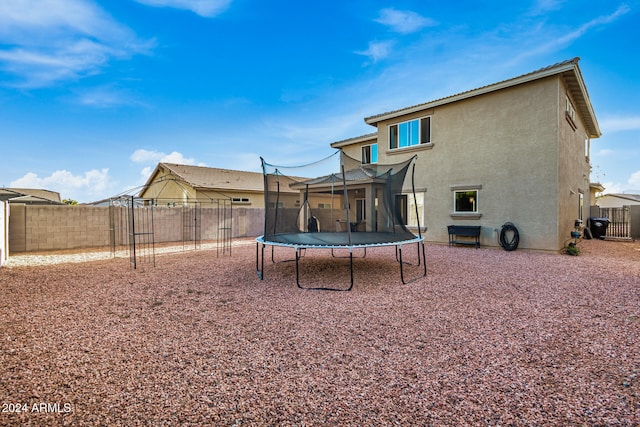 back of house with a trampoline