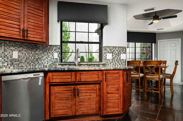 kitchen with decorative backsplash, dark stone counters, ceiling fan, and stainless steel dishwasher