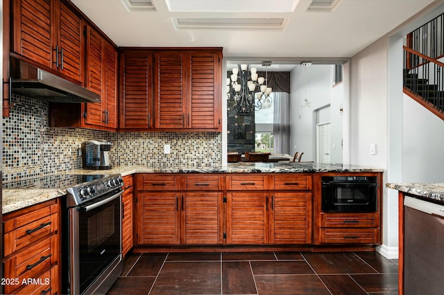 kitchen with light stone counters, under cabinet range hood, tasteful backsplash, an inviting chandelier, and appliances with stainless steel finishes