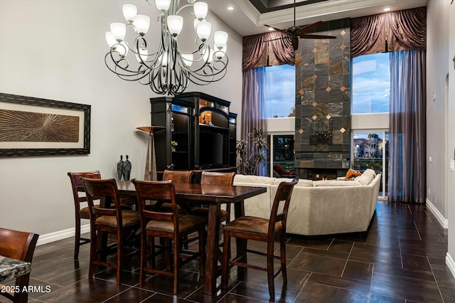 dining space featuring wood finished floors, baseboards, a chandelier, and a fireplace