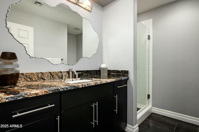 full bathroom featuring visible vents, a shower stall, vanity, and baseboards