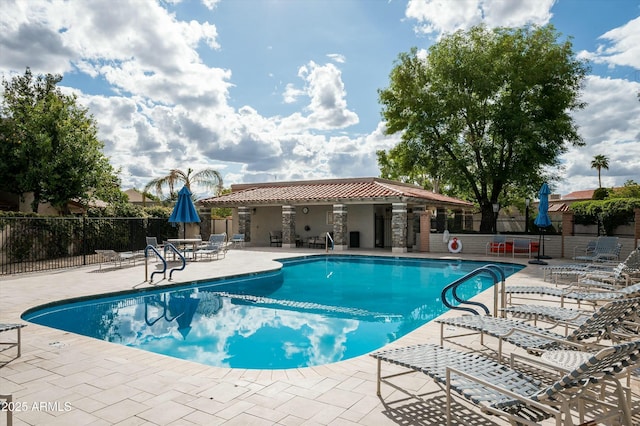 pool featuring fence and a patio area