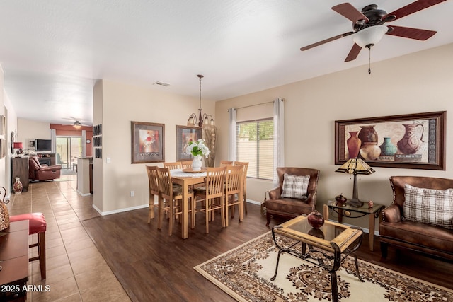 dining room with visible vents, baseboards, ceiling fan with notable chandelier, and wood finished floors