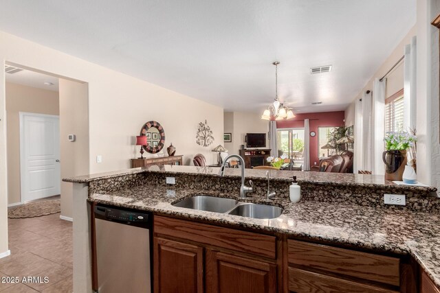 kitchen with a sink, a chandelier, open floor plan, light tile patterned floors, and stainless steel dishwasher