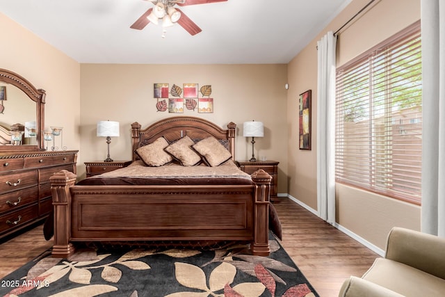 bedroom with baseboards, a ceiling fan, and wood finished floors