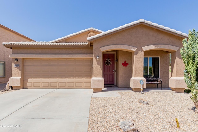 ranch-style home with a garage, stucco siding, and concrete driveway