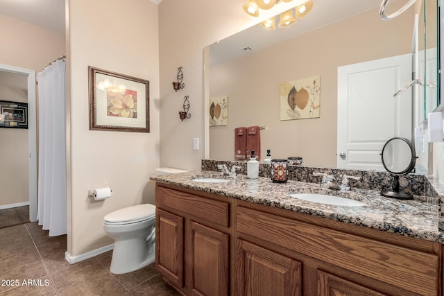 full bath with a sink, tile patterned flooring, toilet, and double vanity